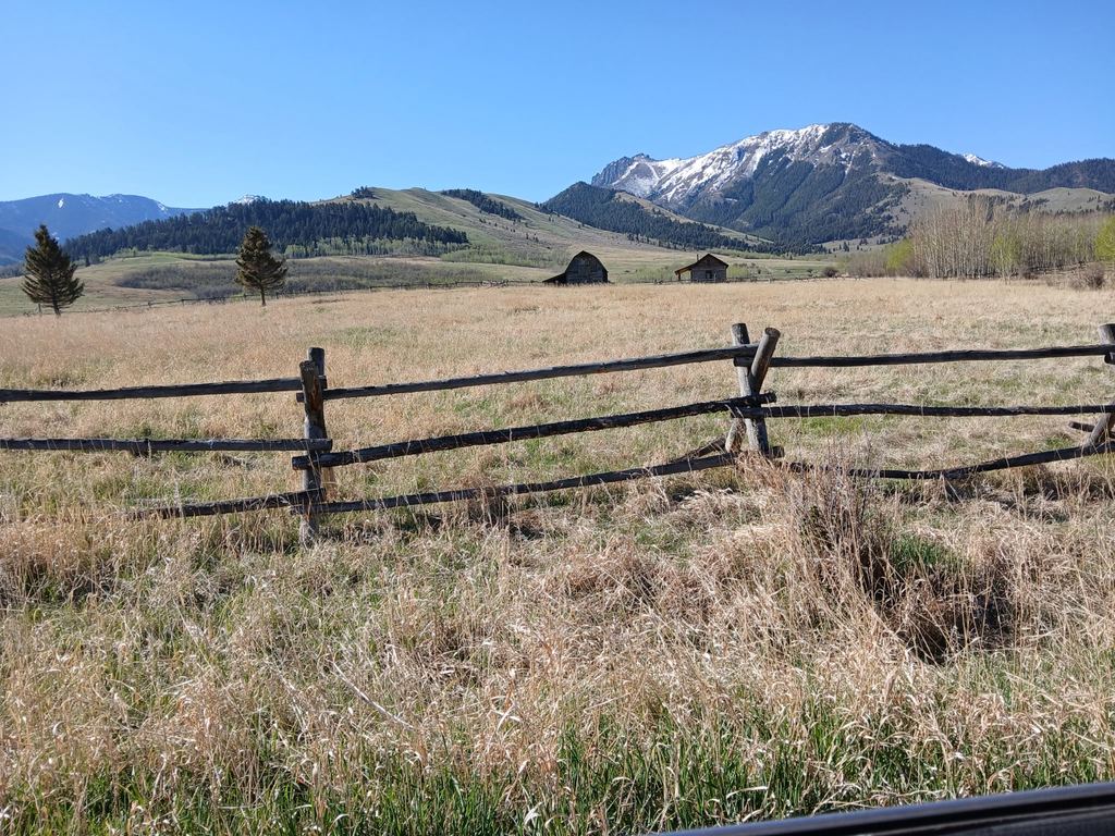 A field and fence beneath the mountains near Livingston, Montana.