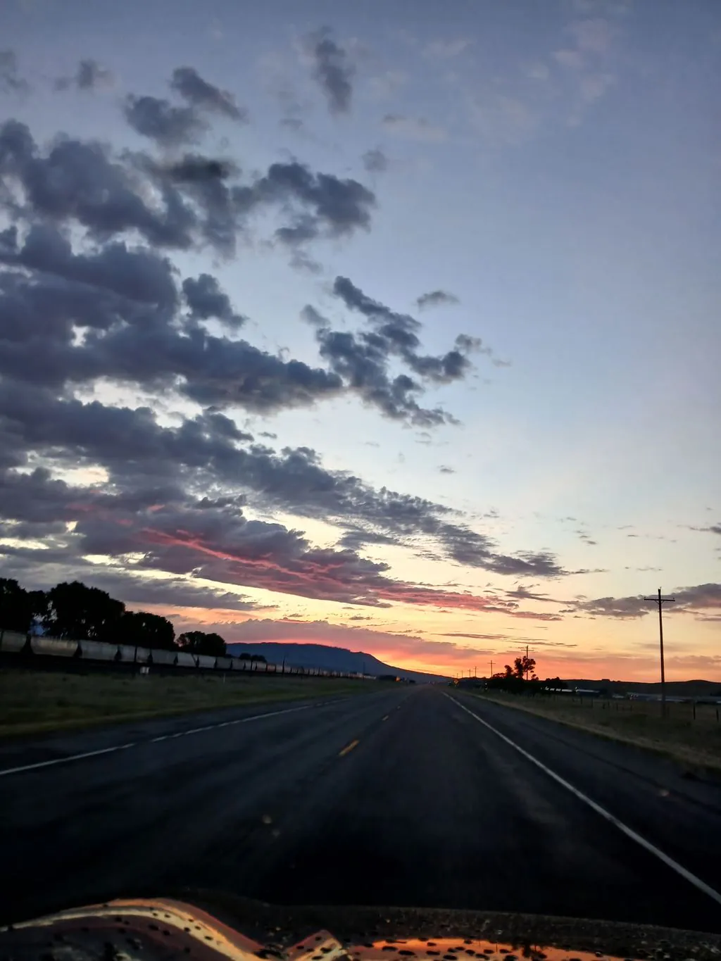 A Montana highway leading toward a sunset.
