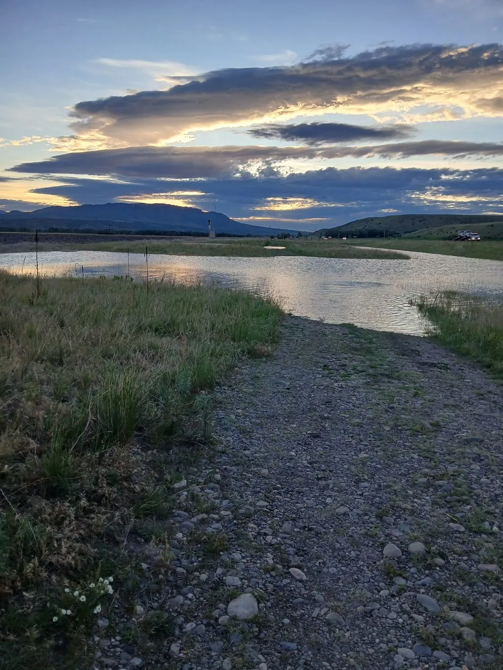 Clouds above Montana mountains and water.